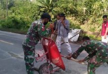 Antisipasi Kecelakaan, Satgas Yonif 642 Perbaiki Jalan Berlubang Bersama Warga